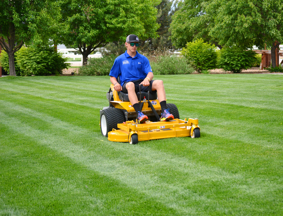 Zachary Clark mowing lawn
